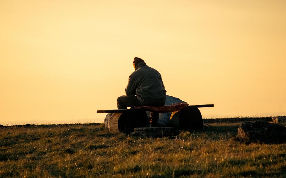 Man sitting in field in Simmozheim, Germany during sunset